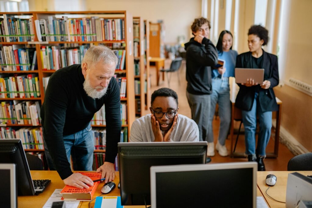 Hands-on across industries. Students and a mentor collaborate in a university library, engaging in educational activities.